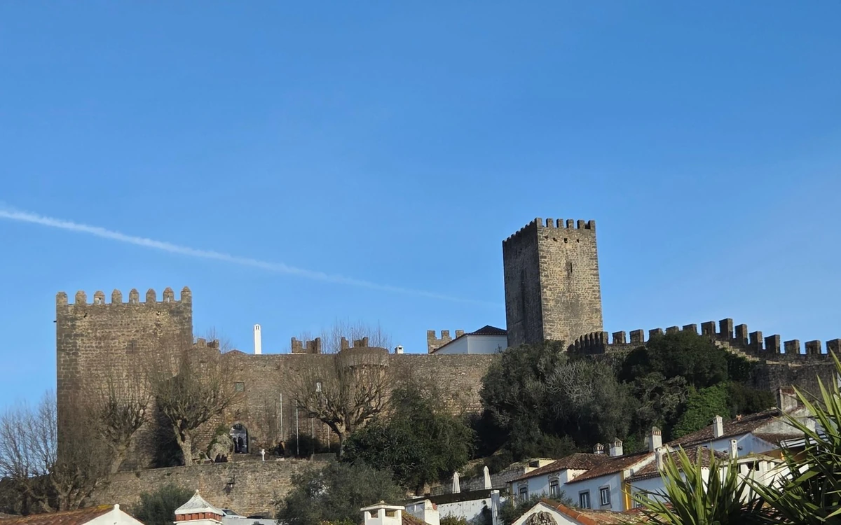 Die Mauern und der Bergfried der Burg von Óbidos über weißen Häusern
