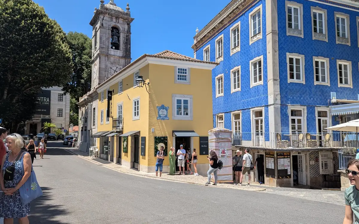 Maison jaune, façade à azulejos bleus et clocher dans une rue du centre de Sintra