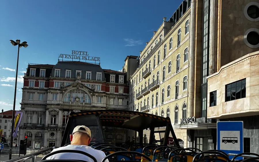 Der Blick vom offenen Oberdeck eines Sightseeing-Busses zwischen prächtigen Stadtgebäuden